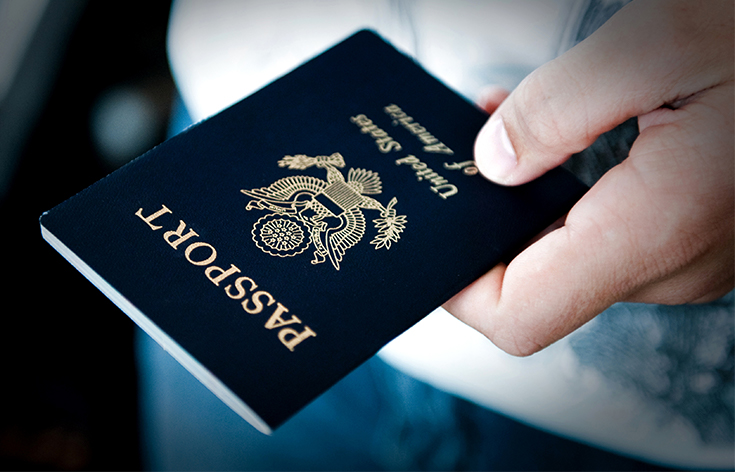 A hand holding an American passport