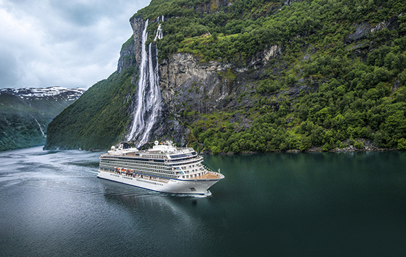 A Viking ocean ship sailing past the Seven Sisters Waterfall in Geiranger, Norway
