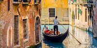 Several people in a gondola sailing through the canals of Venice, Italy