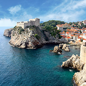 Photo of magnificent white buildings with red tops near the rocky edges of the shoreline