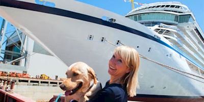 Karine Hagen holding her dog, Finse, in front of a Viking Ocean Ship.